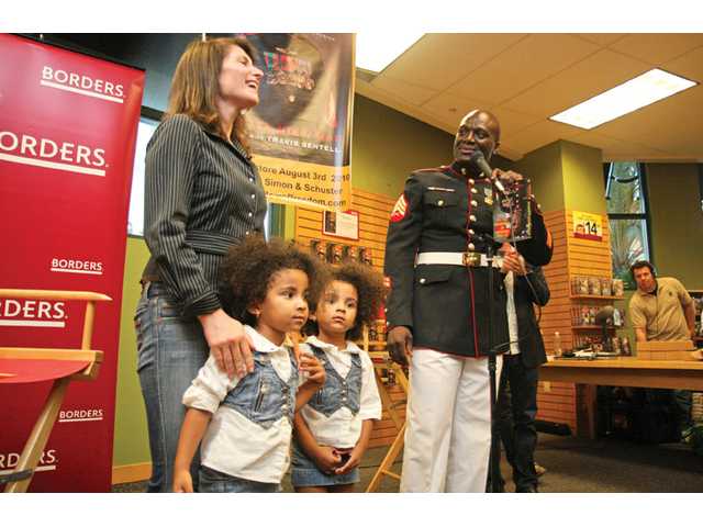 The Stapf family — Garrett, Hope and Colton — get their copy of Tchicaya Missamou’s book signed. Missamou was born in the Congo but came to America to achieve the American dream. He is the owner of Warrior Fitness in Valencia.